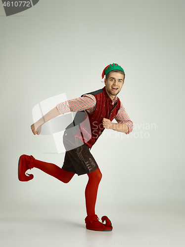 Image of friendly man dressed like a funny gnome posing on gray background