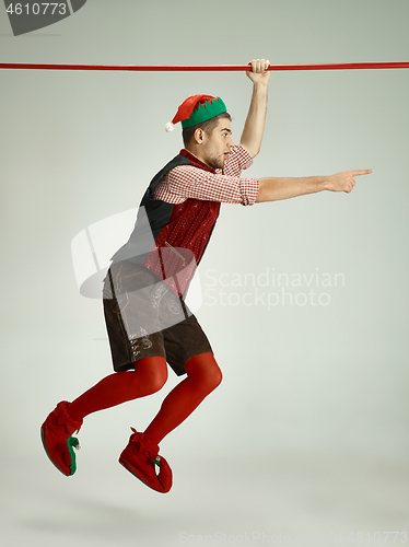 Image of friendly man dressed like a funny gnome posing on gray background