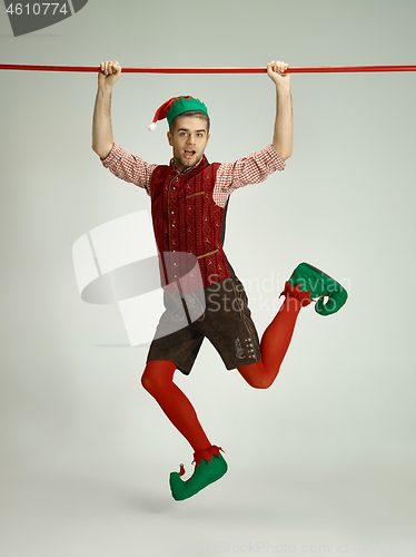 Image of friendly man dressed like a funny gnome posing on gray background