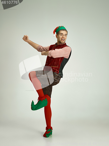 Image of friendly man dressed like a funny gnome posing on gray background