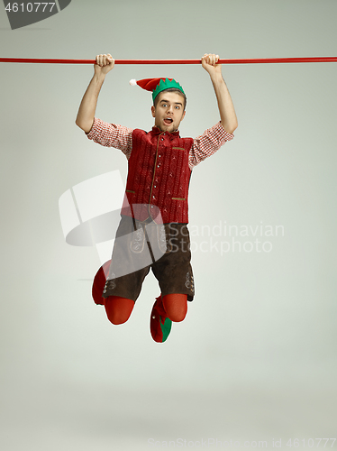 Image of friendly man dressed like a funny gnome posing on gray background