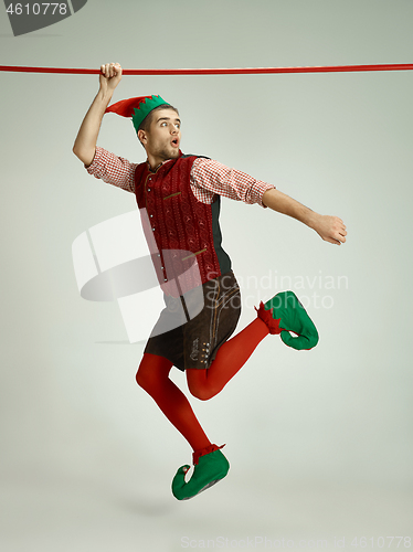 Image of friendly man dressed like a funny gnome posing on gray background