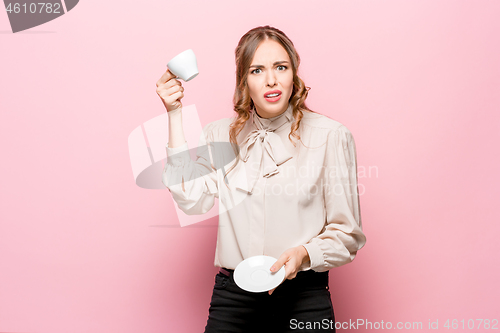 Image of The serious frustrated young beautiful business woman on pink background