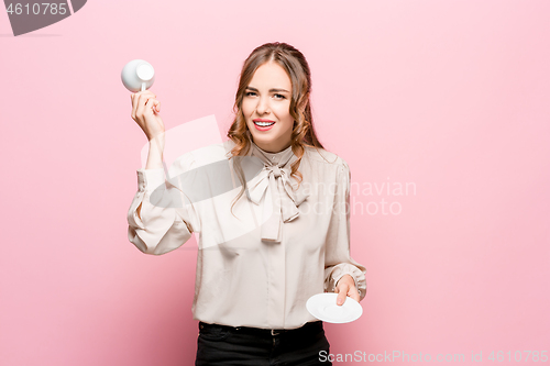 Image of The serious frustrated young beautiful business woman on pink background