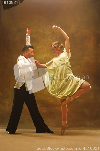 Image of Flexible young modern dance couple posing in studio.