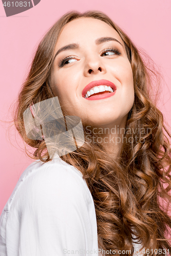 Image of The happy business woman standing and smiling against pink background.