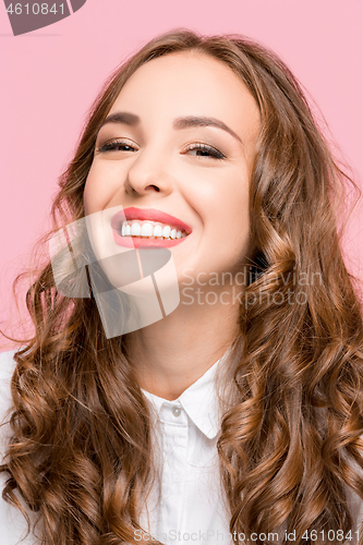 Image of The happy business woman standing and smiling against pink background.