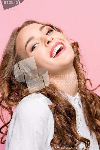 Image of The happy business woman standing and smiling against pink background.