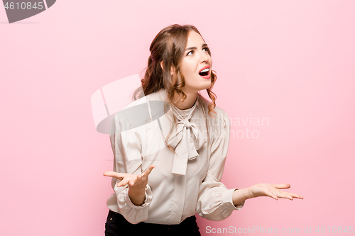 Image of Beautiful female half-length portrait isolated on pink studio backgroud. The young emotional surprised woman