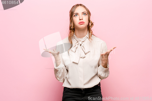 Image of Beautiful female half-length portrait isolated on pink studio backgroud. The young emotional surprised woman