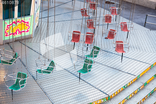 Image of typical carousel with red and green chairs