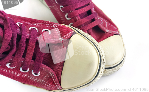 Image of Old wine-colored sneakers on white background