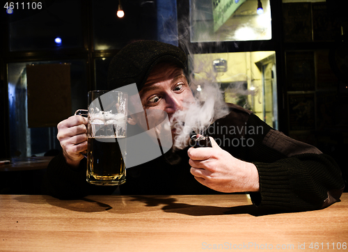 Image of Guy smokes pipe in the bar