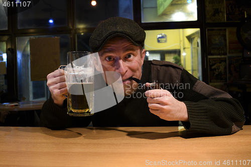 Image of Guy smokes pipe in the bar