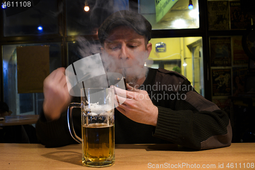 Image of Guy smokes pipe in the bar