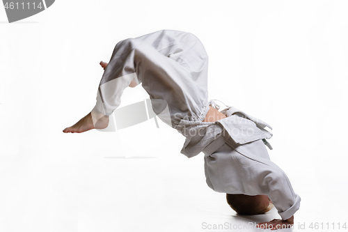 Image of Judo boy in white kimono doing somersault