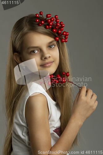 Image of Portrait of a beautiful teenage girl with a bunch of berries in her hand and in her hair