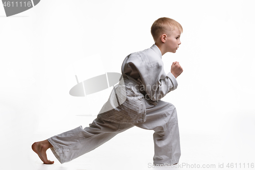 Image of Martial arts student crouches and stretches his legs