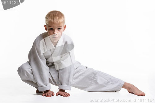 Image of Judoka boy doing stretching at workout