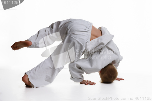 Image of Judo boy doing warm-up spinning around himself while standing on his head