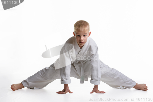 Image of Karate boy tries to sit on a twine