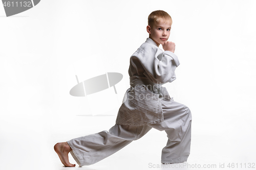 Image of Martial arts student crouches, stretches his legs and looked into the frame