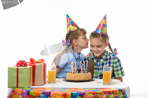 Image of Girl on a birthday celebration says something else in the ear
