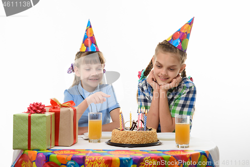 Image of Two girls on a birthday count candles