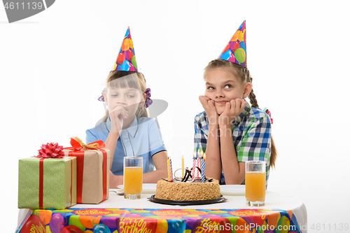 Image of Two girls dream sitting at the festive table on the birthday