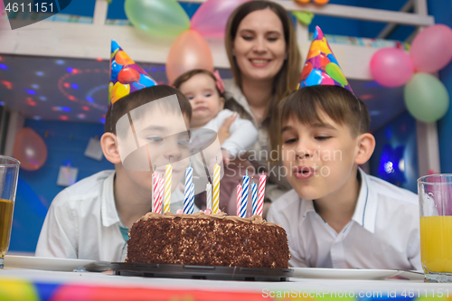 Image of Children blew out candles on a holiday cake