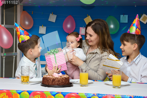 Image of Two boys congratulate mom, mom holds in her arms a six-month-old baby