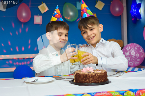 Image of Two brothers banging glasses of juice at a birthday party