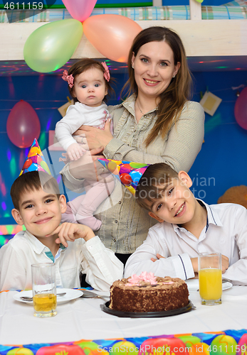 Image of Portrait of mom and three children at a birthday celebration