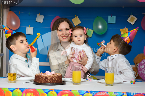 Image of Children joyfully blow in the bells at a birthday party