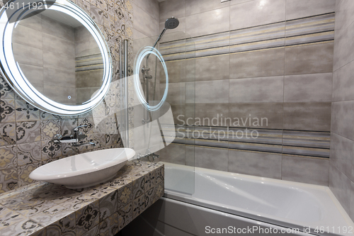 Image of Beautiful modern bathroom, view of the washbasin and bathtub