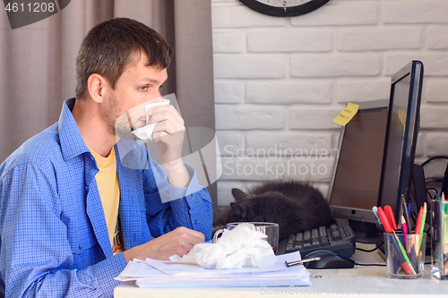 Image of A sick self-employed person wipes his snotty nose with napkins.