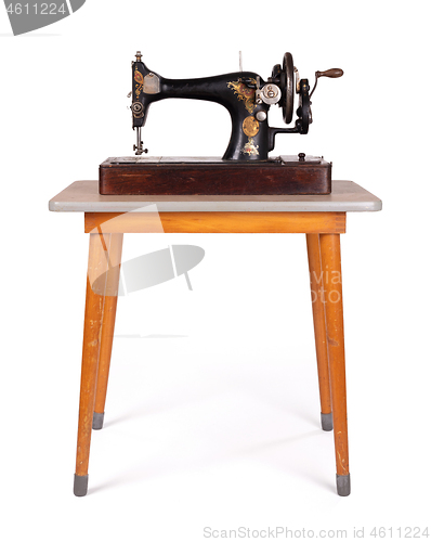 Image of Antique, vintage sewing machine on an old table