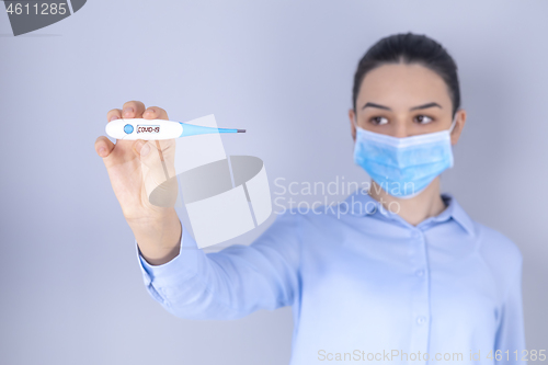 Image of Girl with mask on face check fever