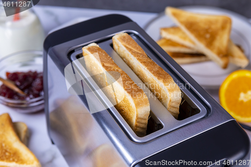 Image of Slices of toast coming out of the toaster for healthy breakfast