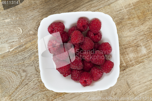 Image of raspberries in a white plate on the table