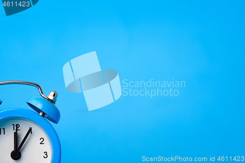 Image of Alarm clock in the lower left corner on a blue background