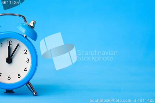 Image of Part of the alarm clock on the left, on the right is an empty place, blue background