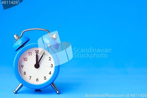 Image of Alarm clock on a blue background, on the right is an empty place