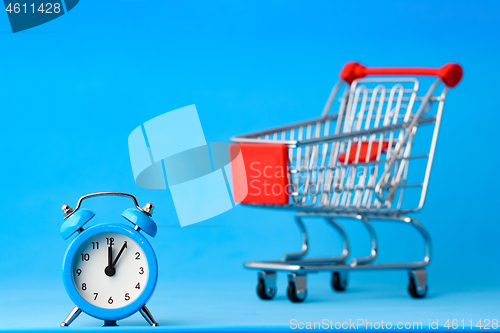 Image of Clock in the foreground, a grocery cart blurry in the background