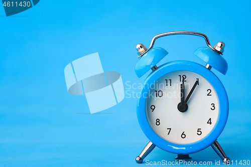 Image of Alarm clock on a blue background, left empty space