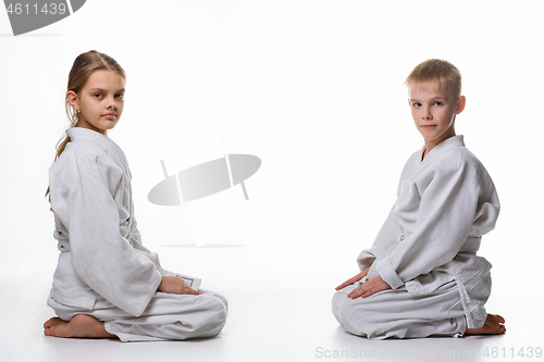 Image of A girl and a boy in a sports kimono sit opposite each other and looked into the frame