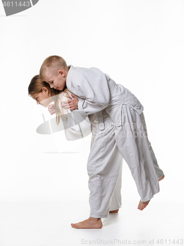 Image of Judo student girl learns to perform throw through the thigh