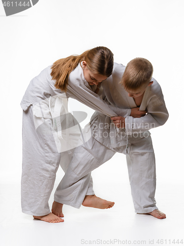 Image of The boy is trying to make a cut for a girl in judo class