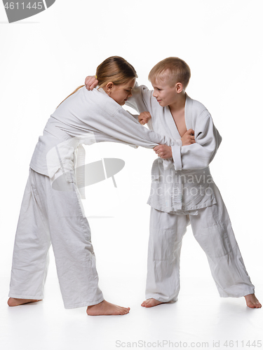 Image of In a judo lesson, a boy and a girl fight and capture