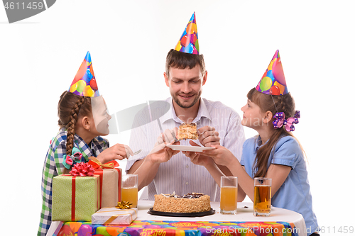 Image of Children ask dad for their piece of holiday cake